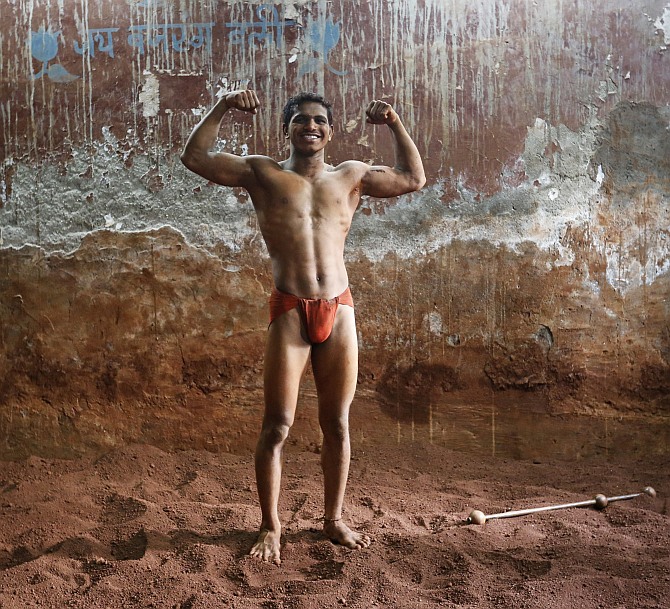 Deepak Mane, a 19-year-old wrestler, poses inside a traditional Indian wrestling centre called Akhaara in Mumbai.