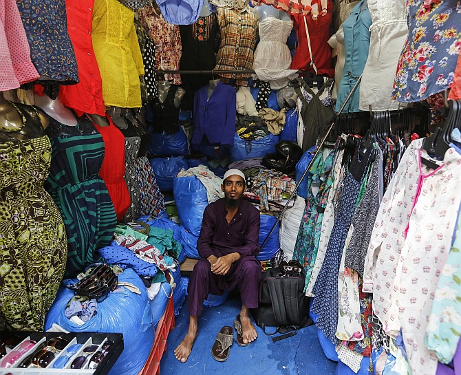 Mohammad Sabir, a 20-year-old salesman, poses inside his roadside shop at a market in Mumbai