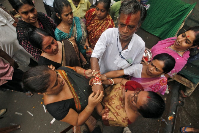Women tie a Rakhi on the wrist of a man at the Sonagachi red-light area in Kolkata.