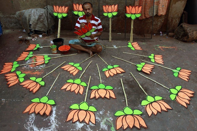 A worker paints a cut-out of a lotus at a workshop ahead of the election.