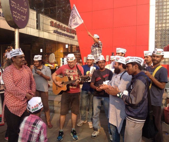 AAP volunteers play the guitar as Balakrishnan watches on during a campaign.