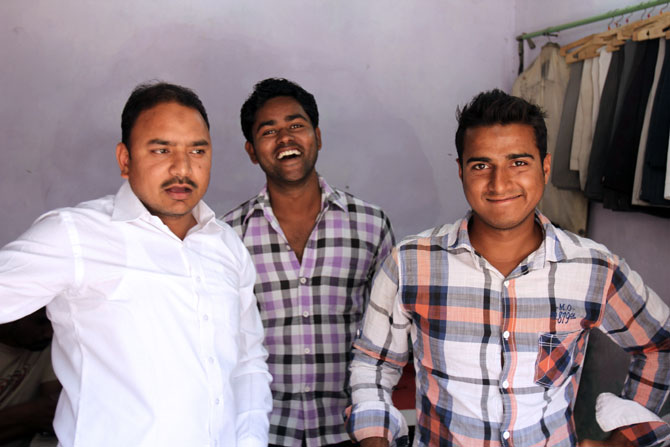 Raees Ansari, left, at his tailoring shop with Abrar Ahmed, a student, and Ansar Khan, an usher at a local multiplex.
