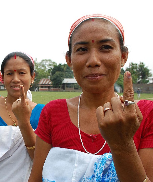 Women display indelible ink mark on their fingers after casting vote outside a polling station during the first phase of elections in Dibrugarh district of Assam