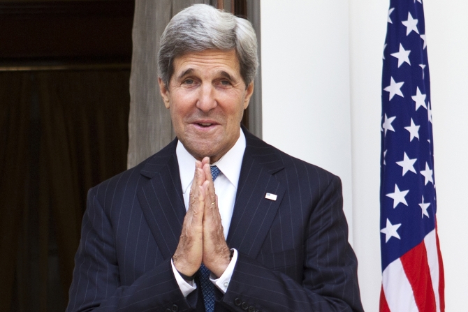 US Secretary of State John Kerry, on his first visit to India as secretary, makes a gesture of greeting to the media at the end of a photo opportunity in New Delhi.
