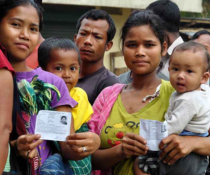 Voters flash their ID cards before casting their ballot at Harlibagan village near Shillong, Meghalaya, on Wednesday