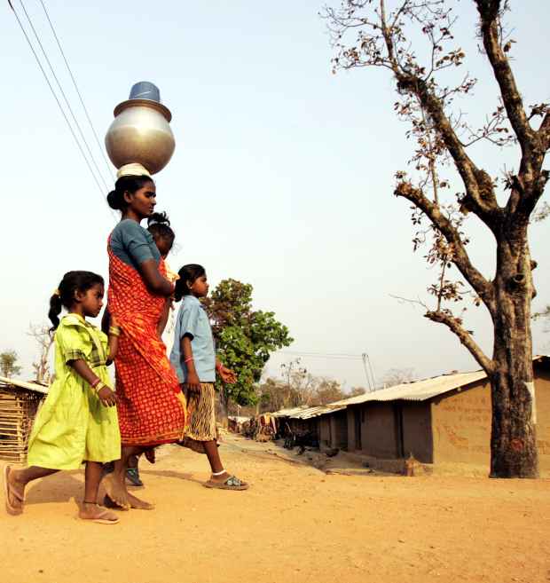 A mother with her kids returns home after fetching water in Maoist prone Bhairamgarh village in Chhattisgarh