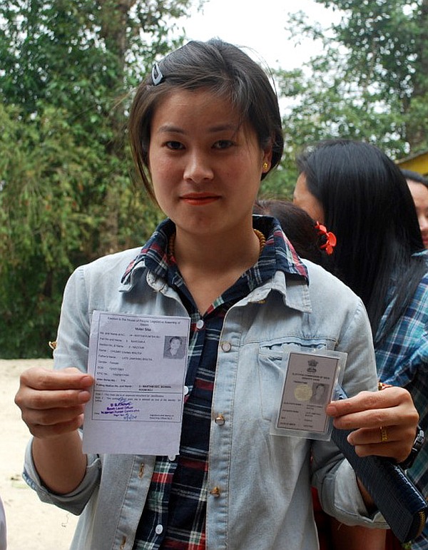 A first time female voter displaying her voter identity card at a polling booth in Sikkim