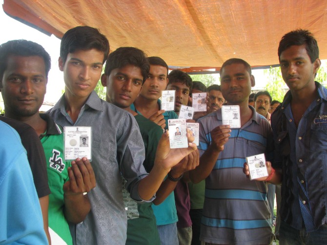 Young voters displaying their voter identity card at a polling booth in Tripura