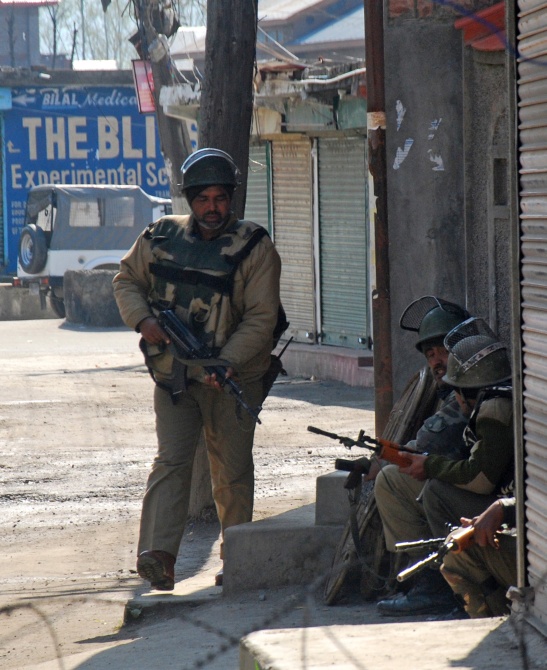 Security personnel take position where the terrorists were holed up.