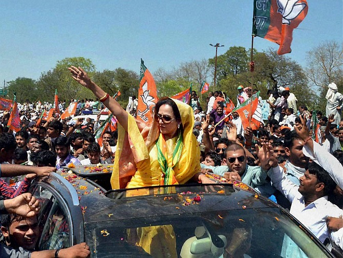 Actress and BJP candidate Hema Malni waves to supporters during her nomination filing procession in Mathura.