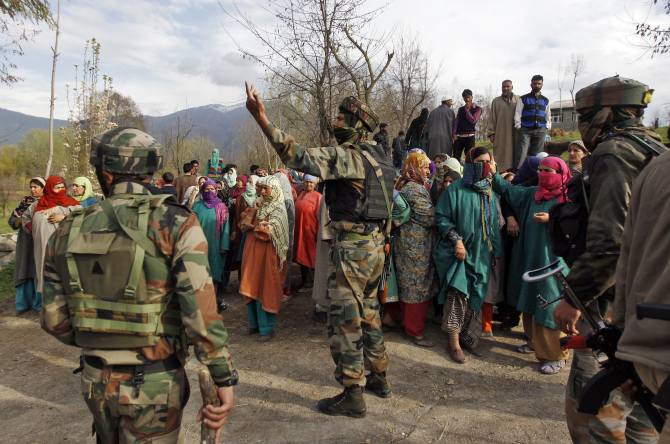Indian soldiers with Kashmiris after a gunbattle with suspected terrorists at Khrew, south of Srinagar, April 13, 2014.