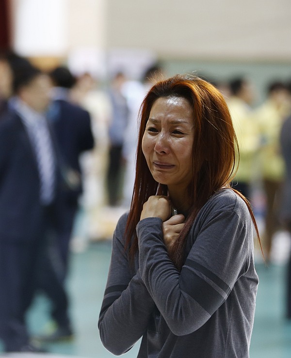 The mother of a passenger who was on a sinking ferry reacts as she finds her son at a gym where rescued passengers gather in Jindo