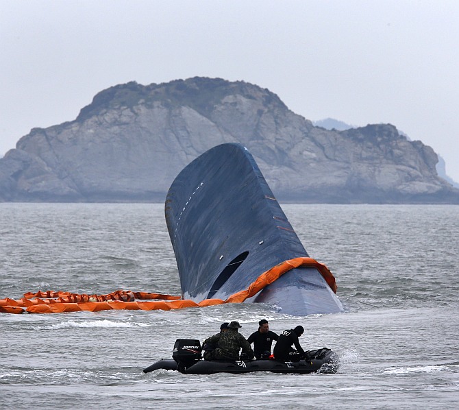 A vessel involved in salvage operations passes near the upturned South Korean ferry Sewol in the sea off Jindo April 17
