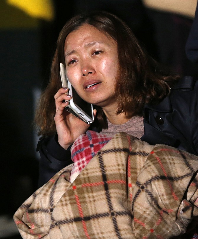 A family member of a missing passenger who was on the South Korean ferry Sewol which sank in the sea off Jindo cries as she waits for a rescue team's arrival at a port where family members of missing passengers gathered in Jindo