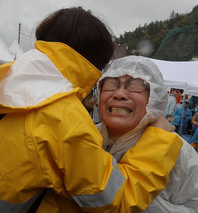 A relative weeps as she waits for missing passengers of a sunken ferry at Jindo port