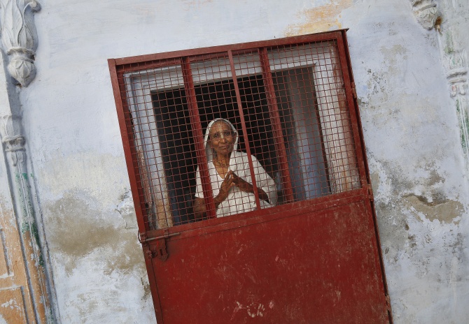 A widow poses at the entrance of a staircase at the Meera Sahavagini ashram in Vrindavan in Uttar Pradesh.