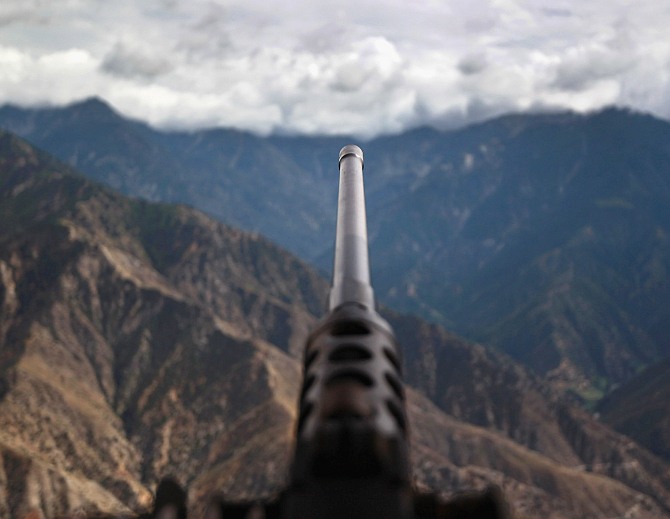 A .50 caliber machine gun points towards Taliban positions from Observation Post Mustang in Kunar province, Afghanistan.