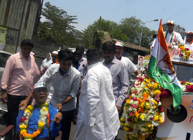 A handicapped constituent is garlanded by Milind Deora in Mazgaon.