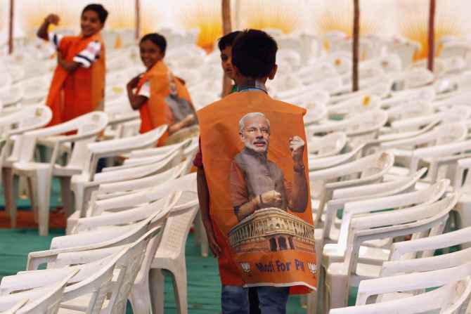 Children wear vests with images of Modi during an election campaign rally in Surendranagar