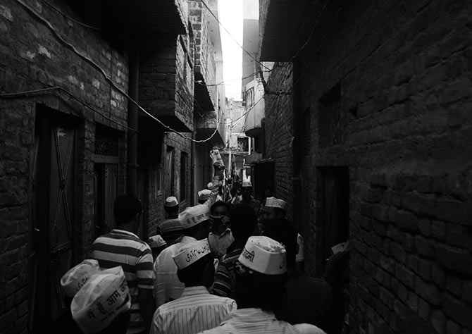 AAP volunteers pass through a narrow bylane in Lucknow. 