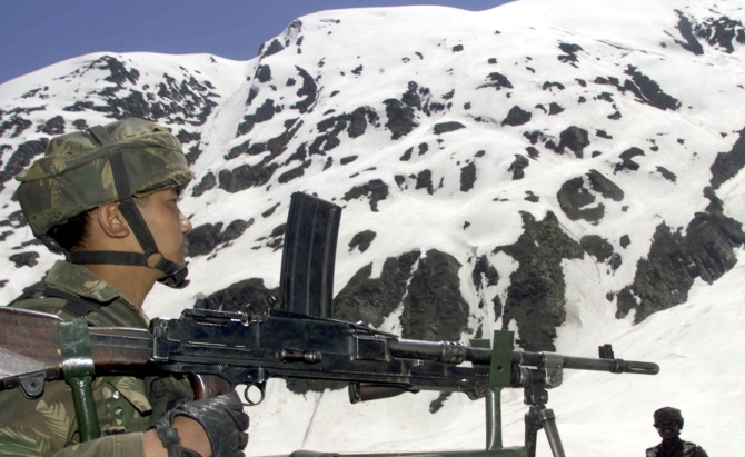 A soldier stands guard at a snow-capped mountain near Srinagar.