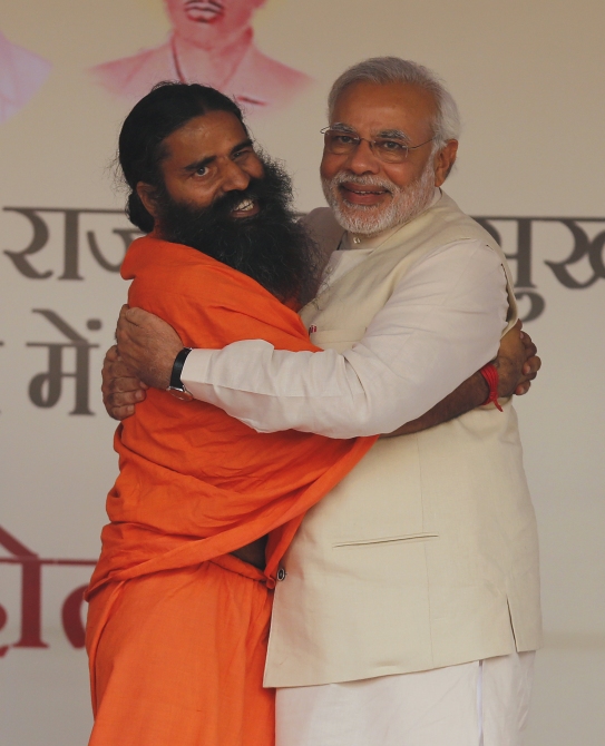 Narendra Modi hugs Ramdev, who recently made anti-Dalit remarks, during a yoga 'mahotsav' in New Delhi.