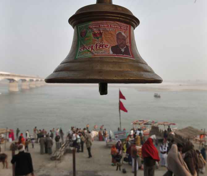 A temple bell pasted with a pamphlet of the BJP candidate is seen on the banks of the Sarayu in Ayodhya.
