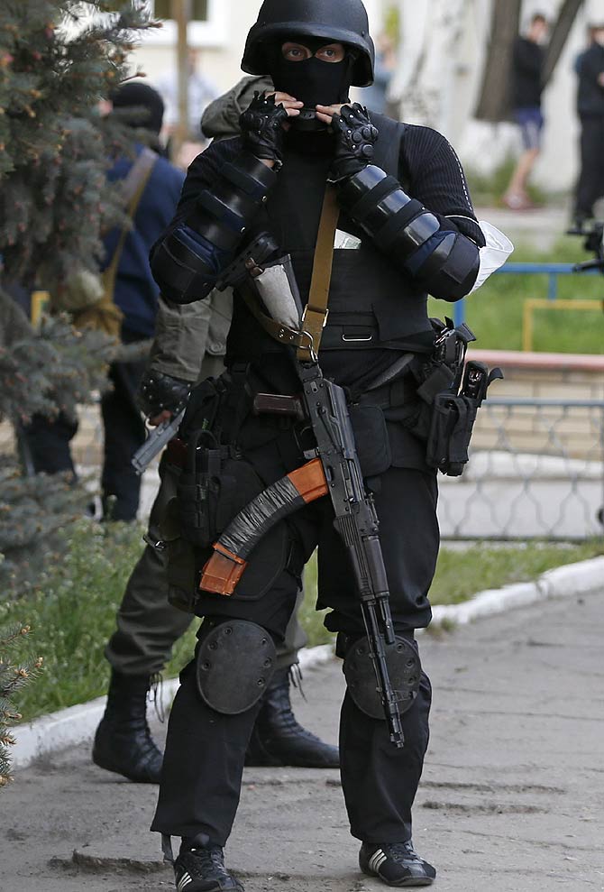 A pro-Russian armed man stands guard near the local police headquarters in Luhansk, eastern Ukraine. 