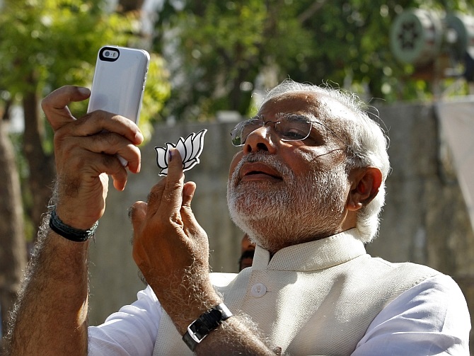 Modi takes a selfie on his phone after he casts his vote in Ahmedabad