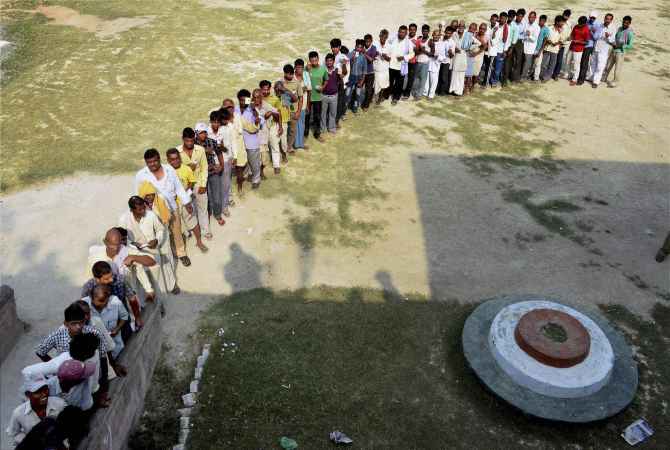 Voters line up to cast their ballot at a polling booth in Bihar's Samastipr district