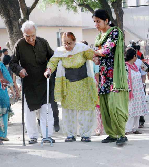 An elderly woman arrives at a polling booth in Lucknow on Wednesday