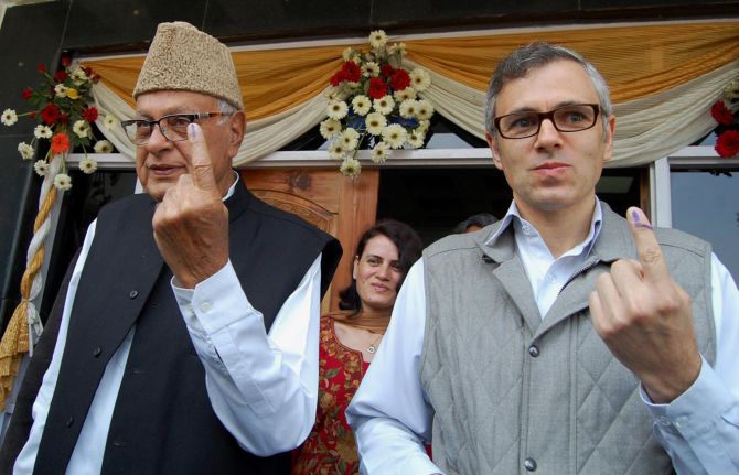 Chief Minister Omar Abdullah with New and Renewable Energy minister Dr Farooq Abdullah show their inked finger after casting their vote