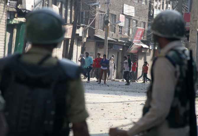 Protestors pelt stones at security personnel during clashes in Srinagar on Friday