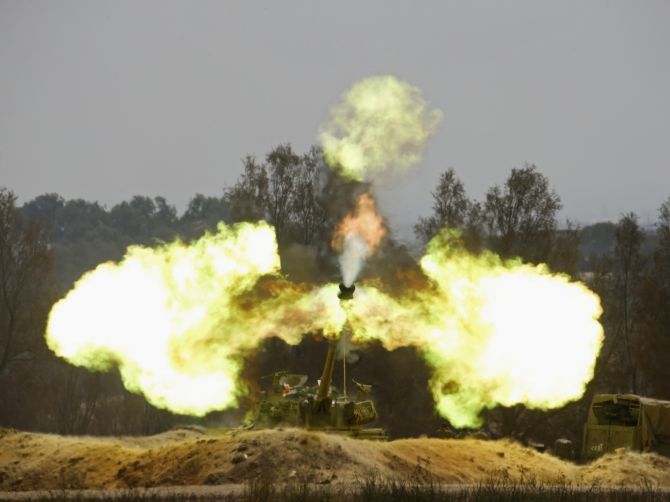 An Israeli mobile artillery unit fires towards the Gaza Strip