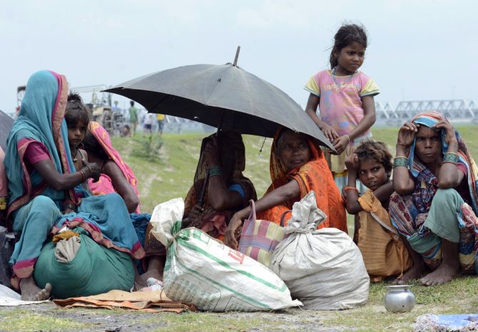 Villagers with their belongings sit in a relief camp after their evacuation at Supaul, Bihar. 