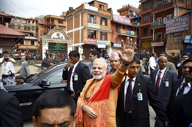 Modi waves at supporters waiting to greet him at the premises of Pashupatinath Temple