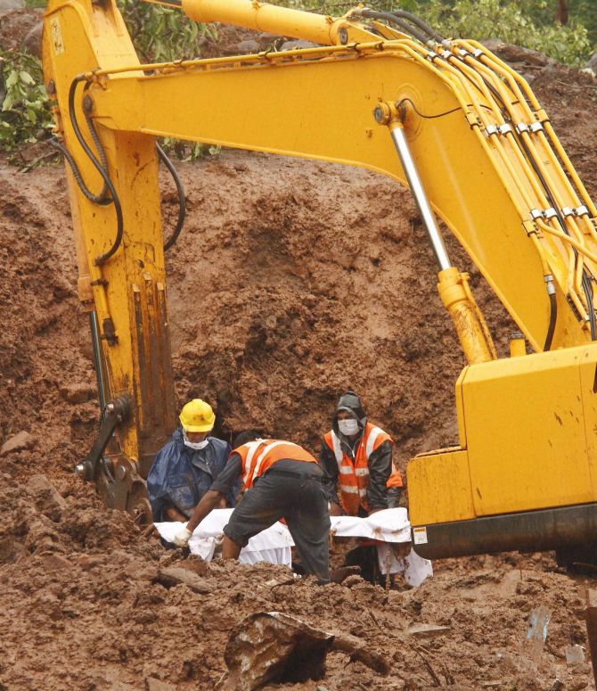 NDRF personnel recover a body from the debris at landslide-hit Malin village in Pune, Maharashtra 