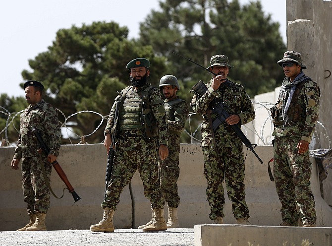 Afghan National Army soldiers keep watch at the gate of a British-run military training academy Camp Qargha, in Kabul August 5