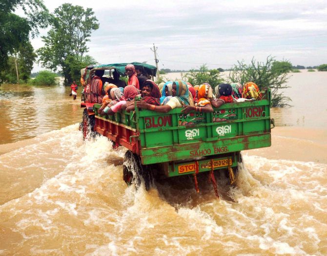People shift by a tractor from a flooded village in Khurda district of Odisha on Tuesday