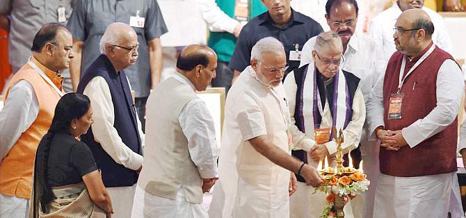 Prime Minister Narendra Modi lights a lamp as BJP President Amit Shah and senior leaders LK Advani, M M Joshi, Rajnath Singh, M Venkaiah Naidu, Arun Jaitley and Gujarat CM Anandiben Patel look on during the partys national council meet