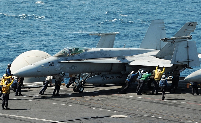 Sailors guide an F/A-18C Hornet assigned to the Valions of Strike Fighter Squadron 15 on the flight deck of the aircraft carrier USS George HW Bush (CVN 77) in the Gulf. Two F/A-18 aircraft from the squadron conducted an airstrike on Friday against Islamic State artillery used against Kurdish forces defending the city of Erbil