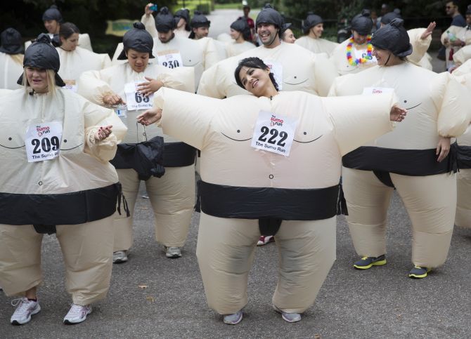 Participants warm up before The Sumo Run in Battersea Park, London.