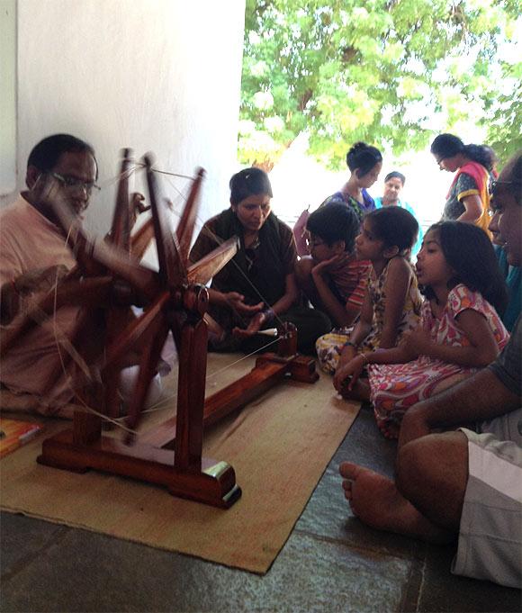 One of Sabarmati Ashram's sanchalaks sits works on the charkha