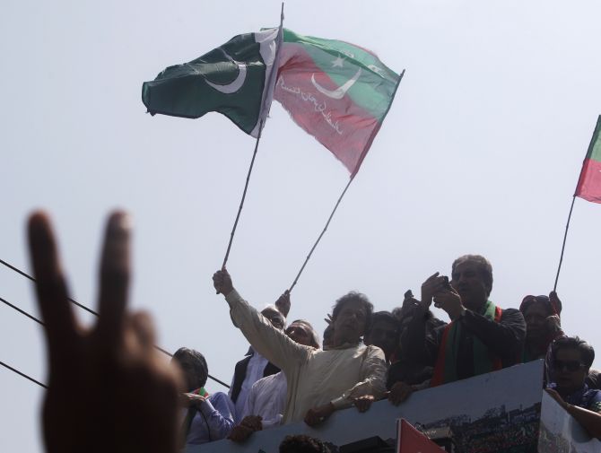 Imran Khan, chairman of PTI, waves a national flag from a truck as he leads the Freedom March in Lahore