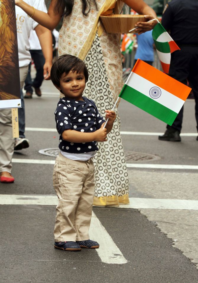 Little boy holds the Indian flag during the parade. 
