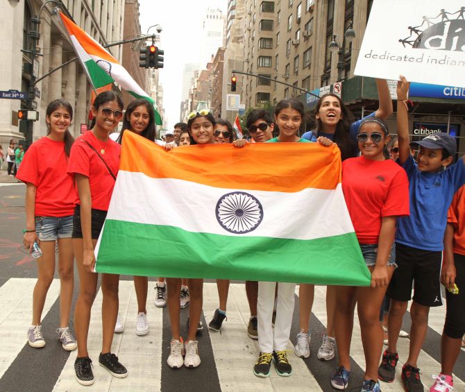 Girls are all smiles at they hold the Tricolour in their hand during the India Day parade. 