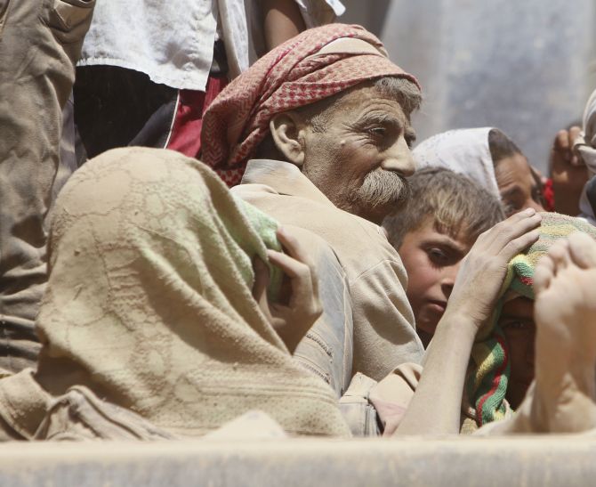 A family waits for aid as they wait to flee Mount Sinjar.