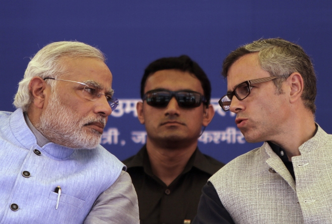 Kashmir's Chief Minister Omar Abdullah (right) speaks with Prime Minister Narendra Modi as a security personnel watches after the inauguration ceremony of a train on a new stretch of railway to the town of Katra, northwest of Jammu.