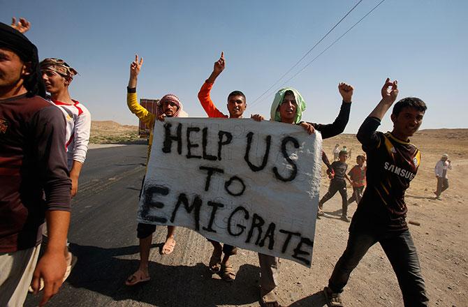 Displaced people from the Yazidi sect take part in a demonstration at the Iraqi-Syrian border crossing in Fishkhabour, Dohuk.