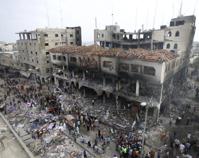 Palestinians gather around the remains of a commercial center, which witnesses said was hit by an Israeli air strike on Saturday, in Rafah in the southern Gaza Strip.